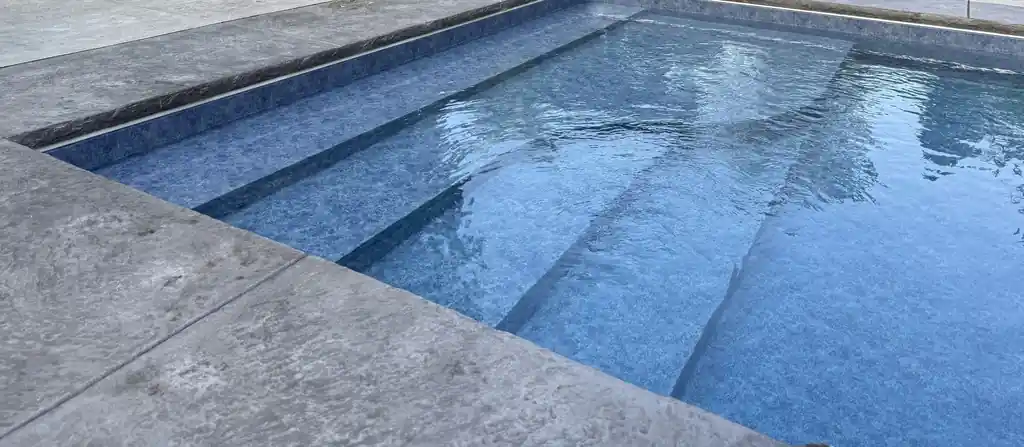 Stamped coping running level along liner steps