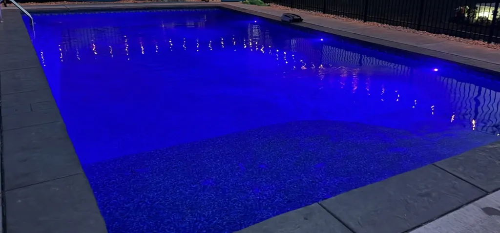 Blue lit pool in the dark, wide view