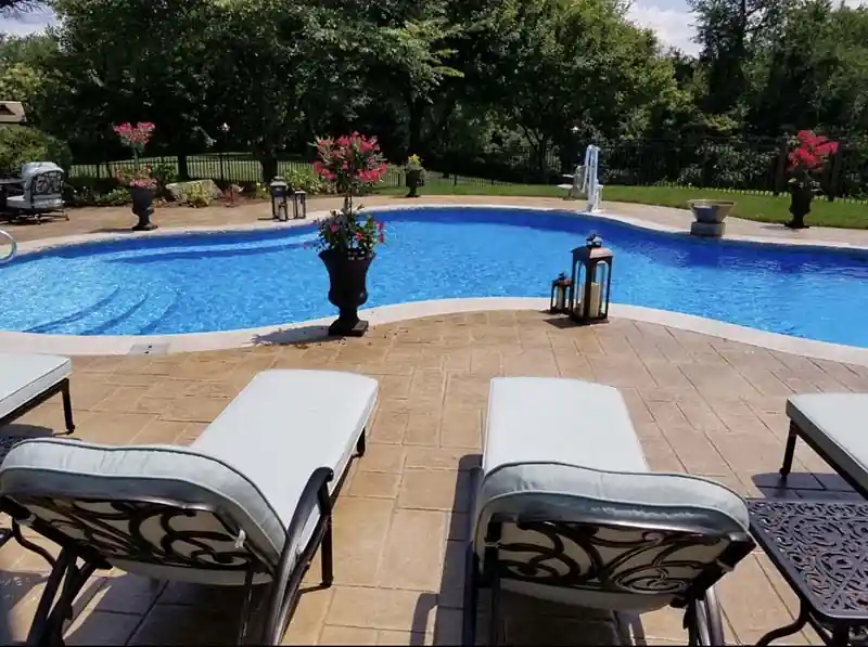 Loungers set out on a stamped patio beside the water