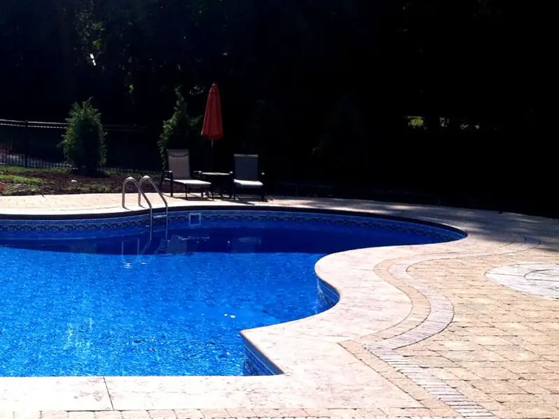 Freeform pool edged with paver coping